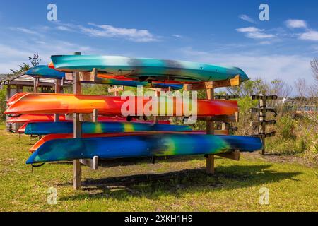 Racks mit bunten Kajaks, die auf Ocracoke Island, North Carolina, USA, gemietet werden können Stockfoto