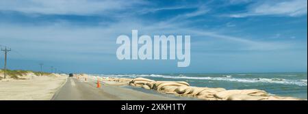 Aus einem fahrenden Auto, Erosionsschutz und Straßenreinigung aus den vergangenen Wochen Sturm entlang Highway 12 auf Hatteras, Insel in Outer Banks NC Stockfoto