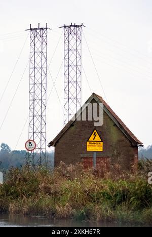 Metallbrücken mit elektrischen Kabeln über dem Fluss waveney Geldeston norfolk england Stockfoto