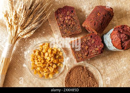 Muffins mit Heidelbeeren, Rosinen und Kakao auf Leinwand mit Weizenohren. Hochwertige Fotos Stockfoto