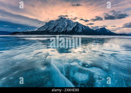 Die Landschaft der natürlichen Bläschen reift auf dem gefrorenen Abraham Lake mit felsigen Bergen im Winter im Kootenay Plains Area, Alberta, Kanada Stockfoto