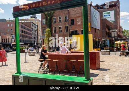 Besucher des Meatpacking District posieren am Freitag, den 19. Juli 2024, für Fotos in dreidimensionalen Nachbildungen der berühmten Edward Hopper Paintings, Nighthawks, Early Sunday Morning und Soir Bleu. Die Ausstellung feiert in Zusammenarbeit mit dem Whitney Museum den 142. Geburtstag von Edward Hoppers am 22. Juli. Das Whitney verfügt über die größte Sammlung von Hopper-Gemälden. (© Richard B. Levine) Stockfoto