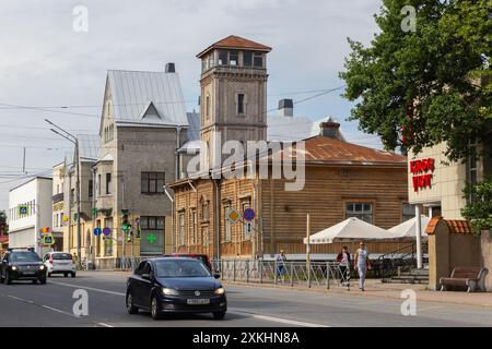 Sortavala, Russland - 21. Juli 2024: Feuerwehrhaus mit Wachturm in der Karelskaja-Straße, einfache Menschen und Autos auf der Straße. Holzgebäude mit t Stockfoto