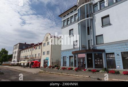 Sortavala, Russland - 21. Juli 2024: Tschkalov-Straße, perspektivisches Foto an einem sonnigen Sommertag. Gewöhnliche Leute laufen die Straße in der Nähe eines geparkten Autos Stockfoto