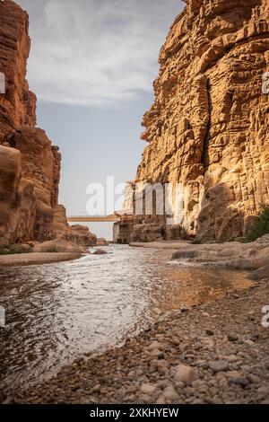 Wadi Mujib Landschaft während des Sonnentages in Jordanien. Wunderschöner Blick auf den Arnon Stream und die Rocky Sandstone Cliff im Nahen Osten. Stockfoto