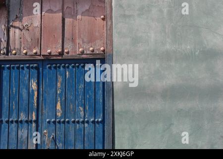 533 Detail, verblasste mintgrüne Wand und ruinierte, abgebrochene rosa und blaue Holztür des Hauses im Kolonialstil an der Westseite der Calle Corona Street. Santiago-Kuba. Stockfoto