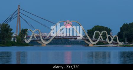 Die Menschen beobachten, wie der Buck Moon von einer Fußgängerbrücke aus in Kiew, Ukraine, über die Stadt aufsteigt. Stockfoto