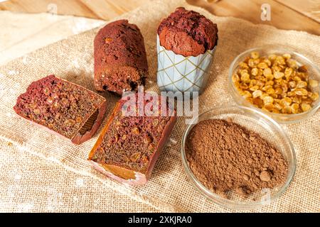 Muffins mit Heidelbeeren, Rosinen und Kakao auf Leinwand mit Weizenohren. Hochwertige Fotos Stockfoto