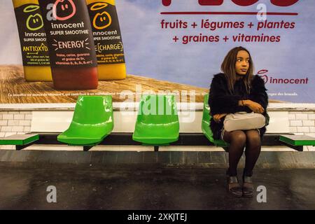 Junge Frau pendelt Junge, weibliche Pendlerin, die auf ihre U-Bahn an der Monceau U-Bahn-Station wartet. Paris, Frankreich. MRYES Paris Monceau U-Bahn-Station Ile de France Frankreich Copyright: XGuidoxKoppesxPhotox Stockfoto