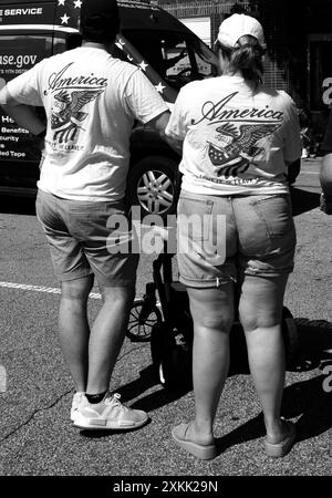 Ein Paar mit passenden „America Love IT or Leave IT“-T-Shirts sieht sich eine Parade am 4. Juli in Hendersonville, North Carolina, an. Stockfoto