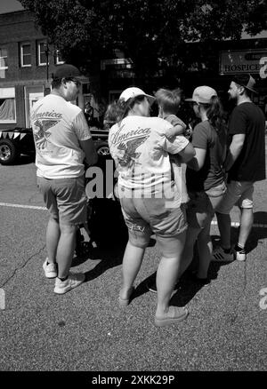 Ein Paar mit passenden „America Love IT or Leave IT“-T-Shirts sieht sich eine Parade am 4. Juli in Hendersonville, North Carolina, an. Stockfoto