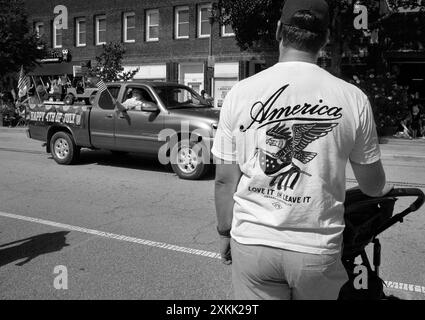 Ein Paar mit passenden „America Love IT or Leave IT“-T-Shirts sieht sich eine Parade am 4. Juli in Hendersonville, North Carolina, an. Stockfoto