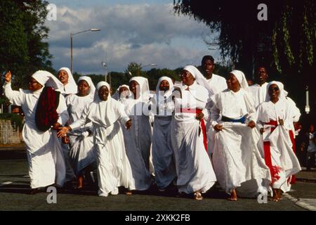 Die Bruderschaft des Kreuzes und des Sterns, die Mitglieder der Kirche, sind auf einen Ausflug und Kreuzzug von London nach Manchester gegangen, um den 19. Jahrestag der Kirche in Großbritannien zu feiern. Moss Side, Manchester, England, 1993 1990er Jahre, UK HOMER SYKES Stockfoto