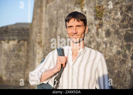 Fröhlicher, fröhlicher Mann mittleren Alters in der Natur an einem warmen sonnigen Tag draußen Stockfoto