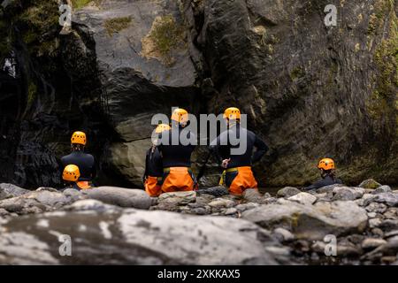 Gruppe von Touristen, die Canyoning-Anzüge im Wasserfall von Salto do Cabrito anziehen. Sao Miguel Insel auf den Azoren. Stockfoto