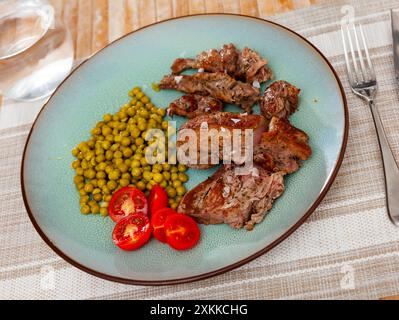 Über offenem Feuer gekochtes Rindfleisch mit appetitlicher Kruste und dunklen Streifen mit Kirschtomaten und Bohnen Stockfoto