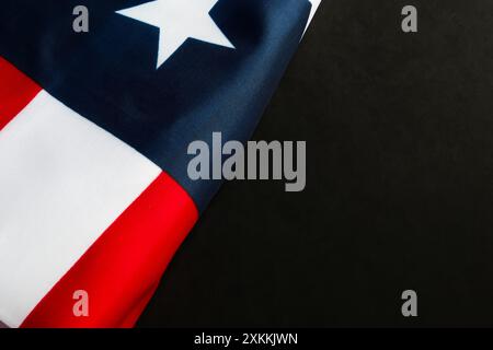 Gefaltete US-Flagge auf dunklem Hintergrund mit Kopierraum. Stockfoto