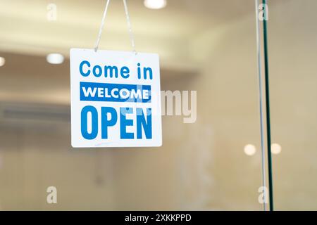 Offenes Schild breit durch den weißen Hintergrund. ÖFFNEN SIE die Schildertafel durch das Glas des Schaufensters. Weißer Text Holztür Vintage Shop Schild o Stockfoto