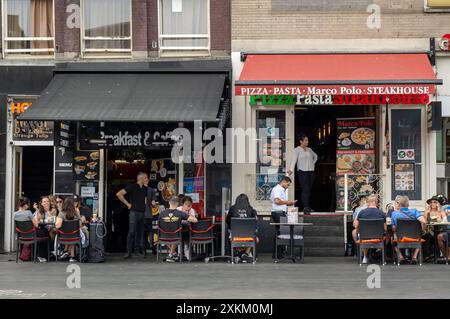 18.06.2023, Niederlande, Nordholland, Amsterdam - zwei konkurrierende Cafè-Restaurants, die sich auf eingehende Touristen spezialisiert haben, auf Damrak im Stadtteil Centrum Stockfoto
