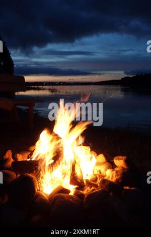 16.07.2020, Polen, Wielkopolska, Lanken - das Lagerfeuer brennt am Ufer von Jezioro Gwiazdy. 00S200716D123CAROEX.JPG [MODELLVERSION: NICHT ZUTREFFEND, P Stockfoto