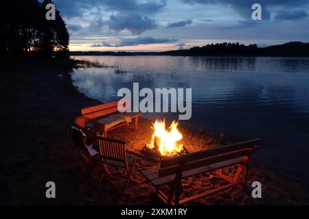 16.07.2020, Polen, Wielkopolska, Lanken - das Lagerfeuer brennt am Ufer von Jezioro Gwiazdy. 00S200716D121CAROEX.JPG [MODELLVERSION: NICHT ZUTREFFEND, P Stockfoto