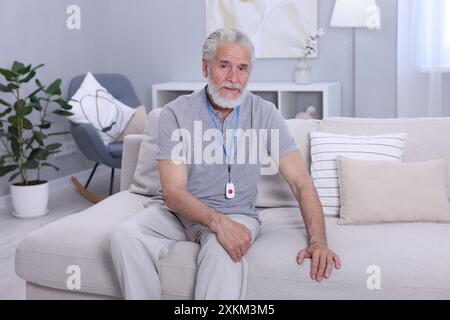 Senior Mann mit Notruftaste zu Hause Stockfoto