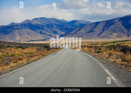 10.03.2024, Argentinien, Patagonien, El Calafate - Straße R11 mit wenig Verkehr zwischen dem Perito Moreno Gletscher und El Calafate vor einem Berg Stockfoto