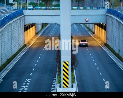 Blick auf Augenhöhe auf einen internationalen Umsteiger, der Tunnel wird mit warmem Licht beleuchtet. Stockfoto