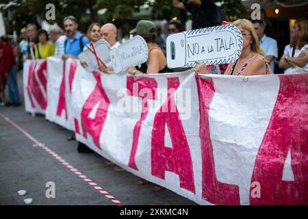 Madrid, Spanien. Juli 2024. Ein Demonstrant hält während eines Protestes gegen das Fällen von Bäumen auf der Plaza Santa Ana ein Banner mit der Aufschrift „Nein zum Fällen“. Der Madrider Stadtrat plant, 30 Bäume auf der Plaza Santa Ana in Madrid zu Fällen, um die Tiefgarage umzubauen. Quelle: SOPA Images Limited/Alamy Live News Stockfoto