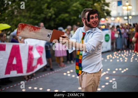 Madrid, Spanien. Juli 2024. Ein Demonstrant mit Maske und dem Gesicht von Jose Luis Martinez Almeida, Bürgermeister von Madrid, hält eine Säge während einer Demonstration gegen das Fällen von Bäumen auf der Plaza Santa Ana. Der Madrider Stadtrat plant, 30 Bäume auf der Plaza Santa Ana in Madrid zu Fällen, um die Tiefgarage umzubauen. Quelle: SOPA Images Limited/Alamy Live News Stockfoto