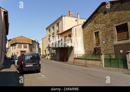 Langeac, Frankreich - 28. Mai 2023: Ein schwarzer Van parkt auf einer schmalen Straße in Langeac, Frankreich, mit einer Reihe von alten Steinhäusern entlang der Straße. Die Bu Stockfoto