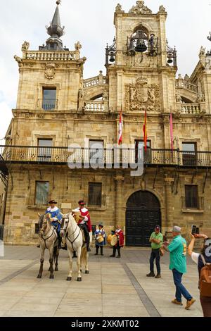 Astorga, Spanien - 3. Juni 2023: Zwei Männer zu Pferd in traditioneller Kleidung reiten durch die Straßen von Astorga, während die Musiker hinter der pla folgen Stockfoto