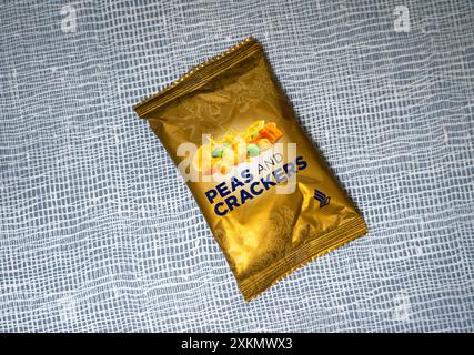 Ein Paket Erbsen und Cracker auf strukturiertem Hintergrund. Snack an Bord von Singapore Airlines. Stockfoto