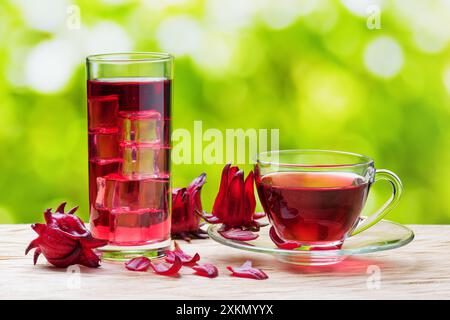 Tasse heißer Hibiskus-Tee und das gleiche kalte Getränk mit Eis Stockfoto