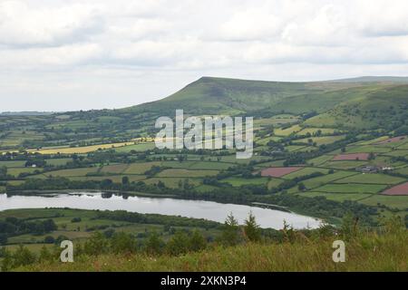 Llangors Lake umgeben von einem Flickenteppich von Feldern und Bergen. Brecon Beacons, Wales, Großbritannien. Stockfoto