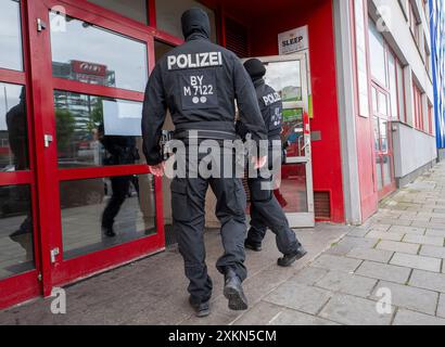 München, Deutschland. Juli 2024. In den frühen Morgenstunden betreten maskierte Polizeibeamte ein Bürogebäude, in dem der Islamische Verband Bayern (IVB) seinen Sitz hat. Quelle: Peter Kneffel/dpa/Alamy Live News Stockfoto