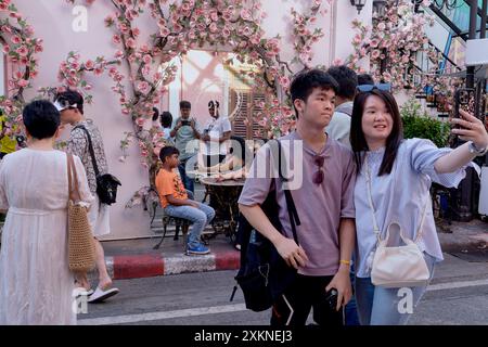 Ein junges chinesisches Touristenpaar an einem beliebten Fotoort in Soi Romanee (Rommani) in der Altstadt von Phuket Town, Thailand, macht Selfies Stockfoto