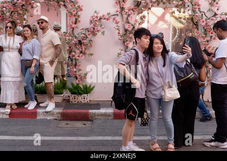 Ein junges chinesisches Touristenpaar an einem beliebten Fotoort in Soi Romanee (Rommani) in der Altstadt von Phuket Town, Thailand, macht Selfies Stockfoto