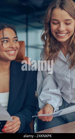 Zwei professionelle Führungskräfte, weibliche Experten, die über die Zusammenarbeit mit Finanzbuchhaltungsunterlagen diskutieren Stockfoto