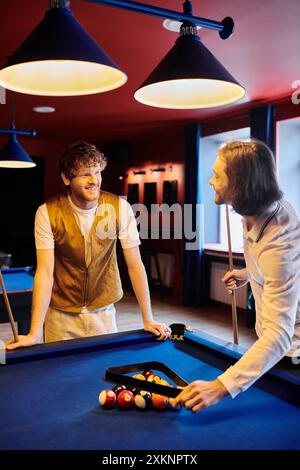 Freunde spielen zusammen Billard, lässig in stilvoller Kleidung. Stockfoto