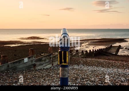 Ein sprechendes Teleskop am Whitstable East Quay Beach mit Blick auf das Meer über die Themsmündung bei Sonnenuntergang. Stockfoto