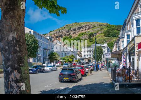 Mostyn Street in Llandudno mit dem Empire Hotel, das sich unter dem Großen Orme befindet. Stockfoto