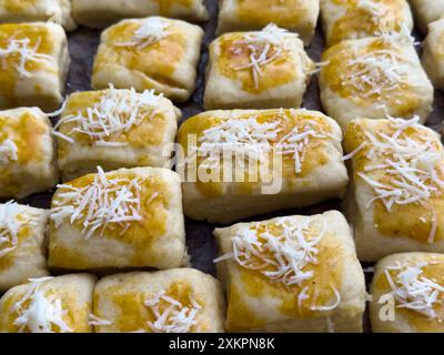 Frisch zubereitetes Käsegebäck mit geriebenem Käsebelag zum Backen Stockfoto