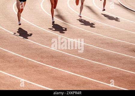 Beginn des 800-Meter-Rennens, Frauenbeine, Schatten im roten Stadion Stockfoto