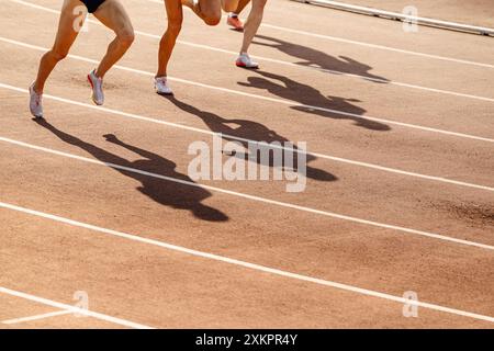 Frauen Beine und Schatten im roten Stadion, Mittelstreckenrennen Stockfoto