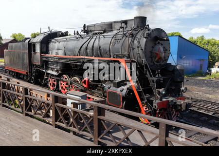 Schwarze Retro-Dampflokomotive aus UdSSR-Zeiten befindet sich an einem sonnigen Sommertag in der Nähe des Bahnsteigs am Hauptbahnhof von Sortavala Stockfoto