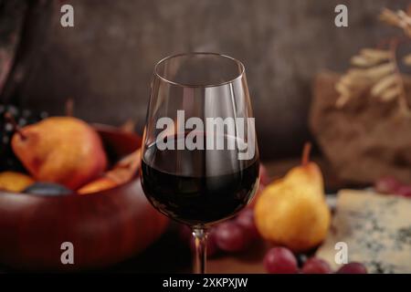 Herbstpicknick mit Wein- und Käseplatte, Früchten und trockenen Blättern Stockfoto