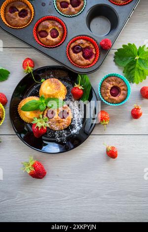 Süße Quark-Muffins mit Erdbeerfüllung, auf einem Teller auf einem Holztisch. Stockfoto