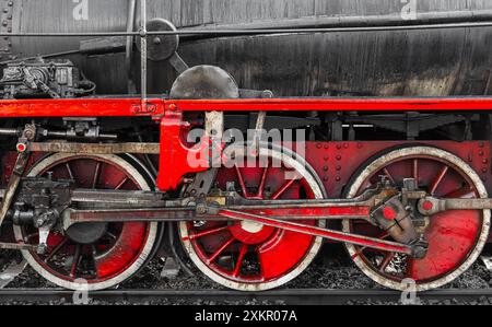 Rote Räder und Details einer alten schwarzen Dampflokomotive, Nahaufnahme Stockfoto