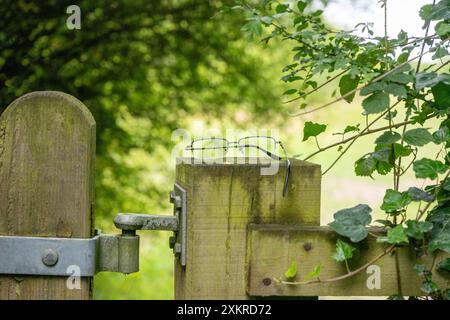 Ein verlorenes Paar Metallbrillen auf einem großen hölzernen Torpfosten, um den Besitzer zu finden. Stockfoto